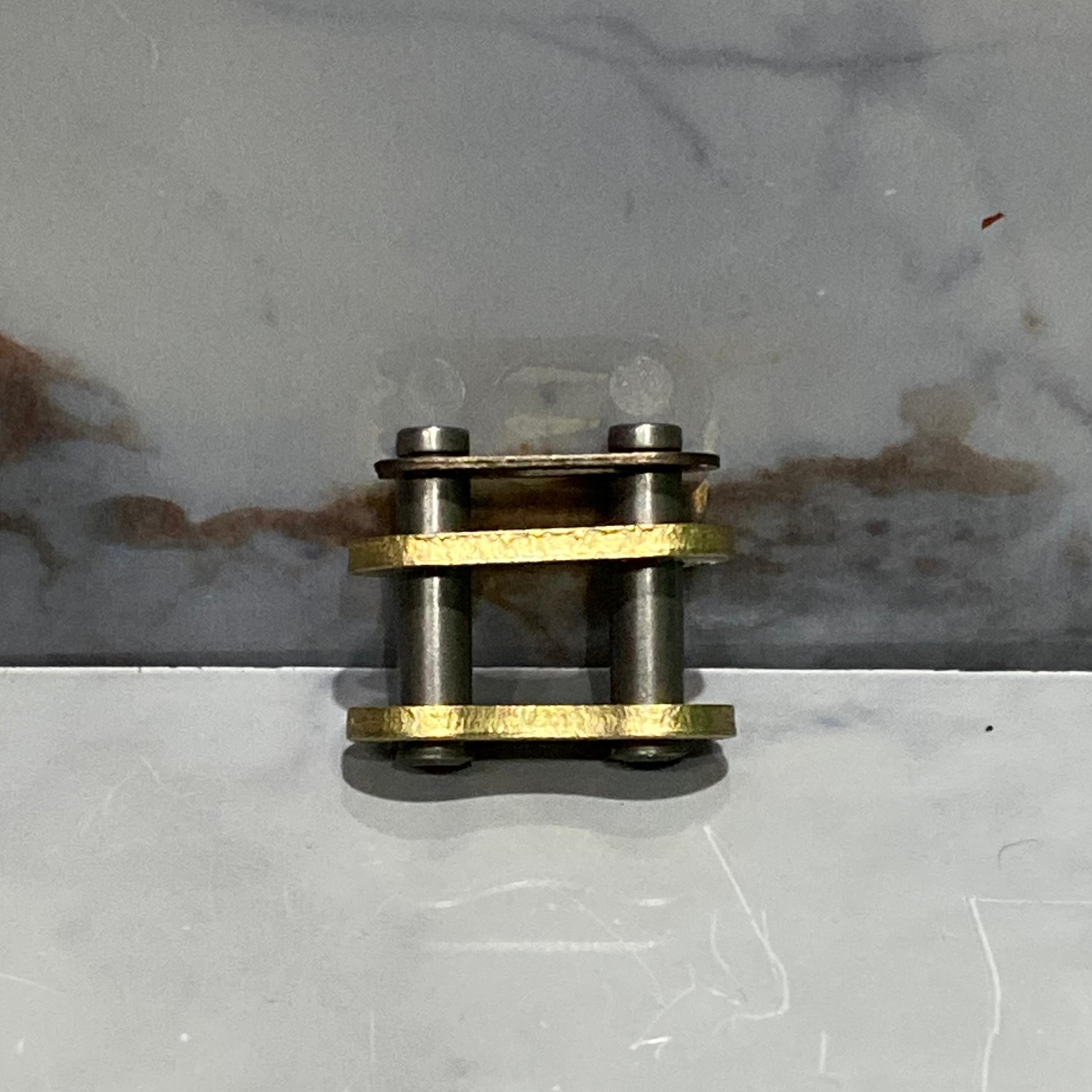 PEGA DE CADENA 428 DORADA Y NEGRA